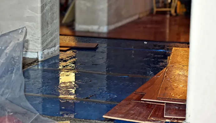 Cupped and buckled hardwood floor from water damage in a Calabasas, CA home